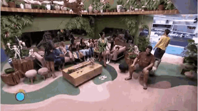 a group of people are sitting in a living room with a table .