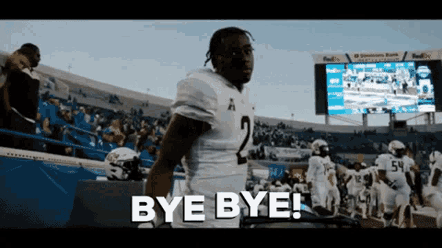 a football player says bye bye while walking off the field