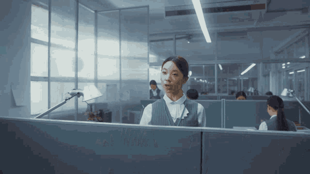 a woman with a green lanyard around her neck stands behind a desk