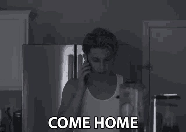 a black and white photo of a man talking on a cell phone with the words come home written below him
