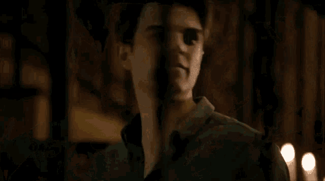 a man and a woman are standing next to each other and talking in a dark room .