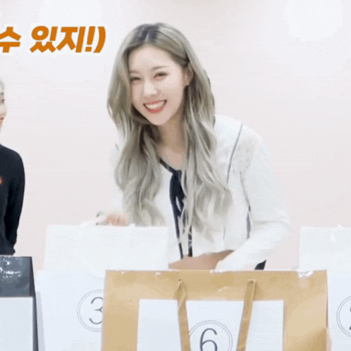 a woman is smiling while holding a bag with the number 6 on it