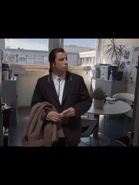 a man in a suit and tie stands in a room