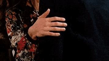 a man and woman are kissing and the woman is wearing a floral top