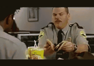 a police officer is eating a hamburger in a restaurant