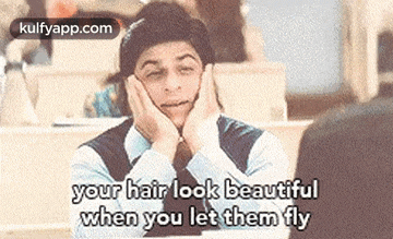 a man is sitting in a classroom with his hands on his face and the words `` your hair look beautiful when you let them fly '' .