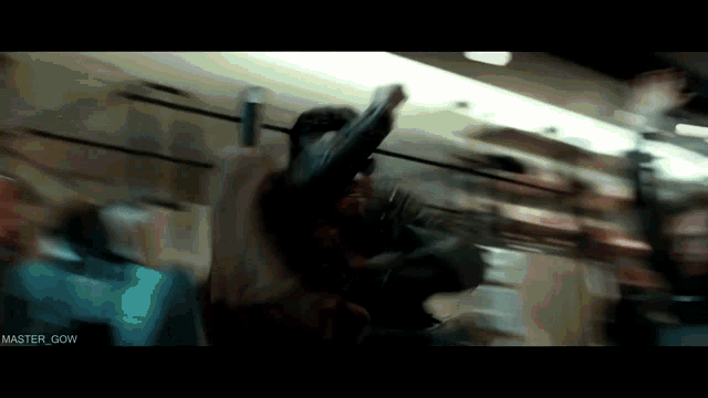 a blurry picture of a man holding a gun with master gow written on the bottom