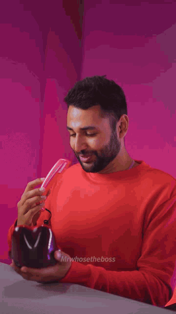 a man with his tongue sticking out is wearing a red shirt that says mr. whosetheboss