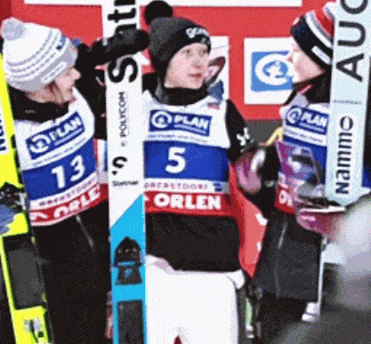 a group of skiers are standing next to each other with one wearing the number 5