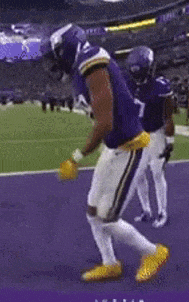 a football player with the number 8 on his jersey is dancing on the field .