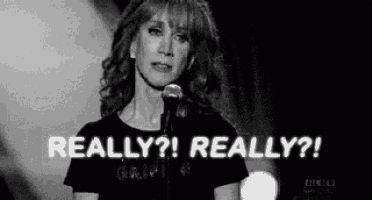 a woman is standing in front of a microphone and says `` really ? really ? '' .