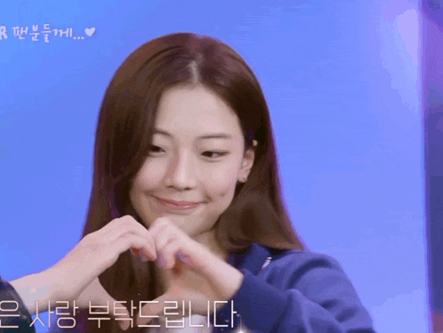 a woman making a heart shape with her hands with a blue background