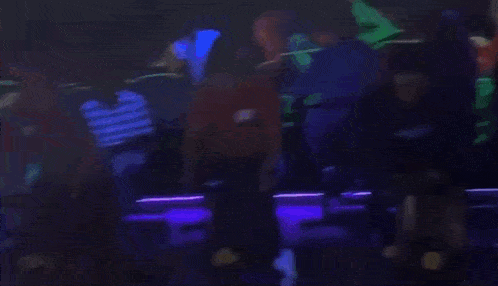 a group of people are standing in a dark room with glow in the dark paint .