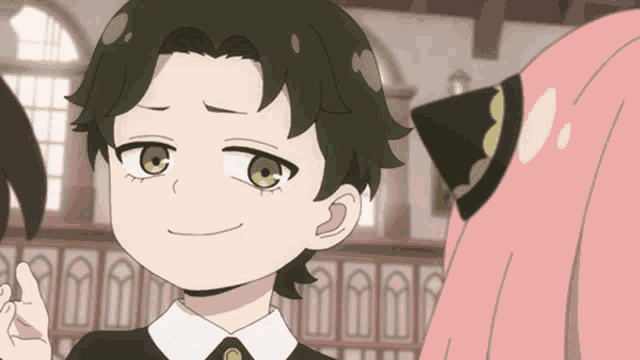 a little boy with green eyes is smiling and giving a thumbs up
