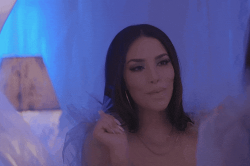 a woman in a white dress looks at herself in a mirror
