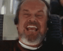 a man with a beard is wearing headphones and smiling while sitting on a plane .