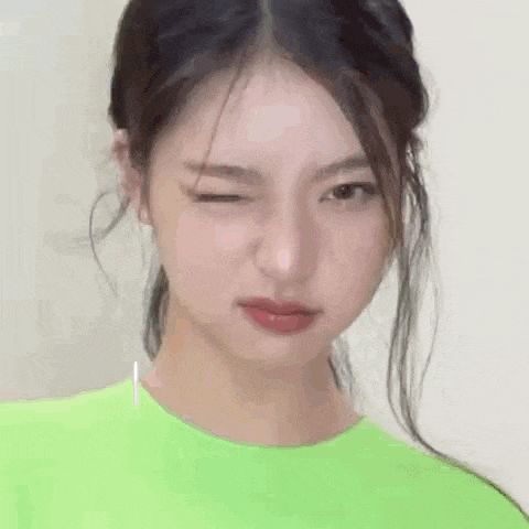 a close up of a woman making a funny face while wearing a neon green shirt .