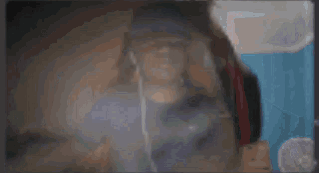 a blurred image of a person 's face with a blue background