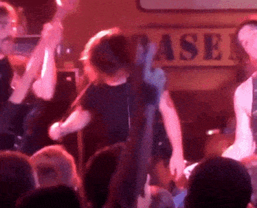 a group of people dancing in front of a sign that says baser