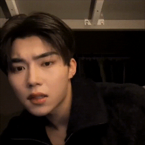 a close up of a young man 's face in a dark room .