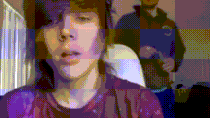 a man in a purple shirt looks at the camera
