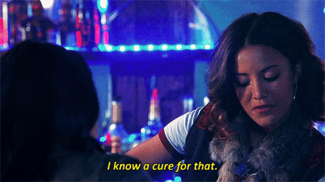 a woman in a fur vest is talking to another woman and says i know a cure for that
