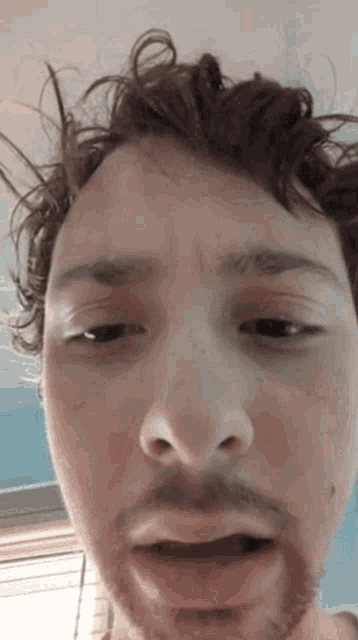 a man with a beard is making a funny face