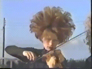 a woman with a large wig is playing the violin