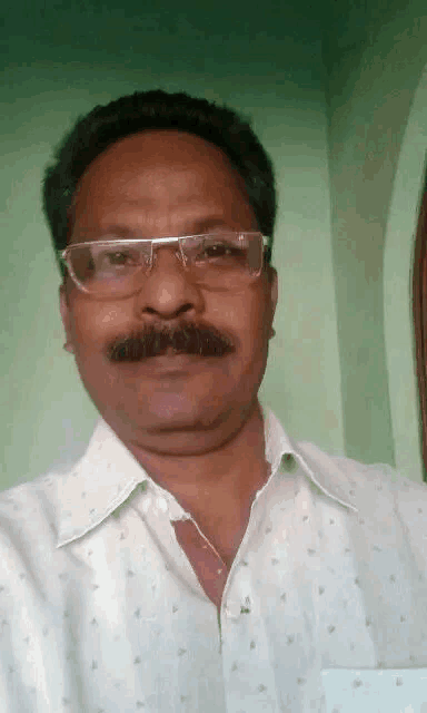 a man with glasses and a mustache is taking a selfie