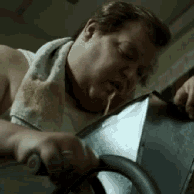 a man with a towel around his neck is sitting on a machine