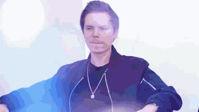 a man in a black jacket is wearing headphones and a necklace .