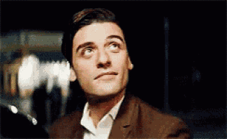 a man in a suit and white shirt is looking up at something .