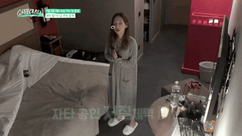 a woman is standing in a hotel room with korean writing on the walls