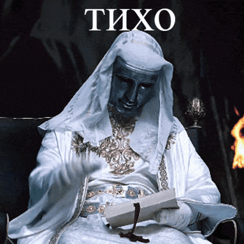 a man in a white robe is reading a book with the word tixo on the bottom