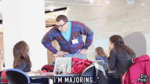 a man in a sweater says " i 'm majoring " to a group of people