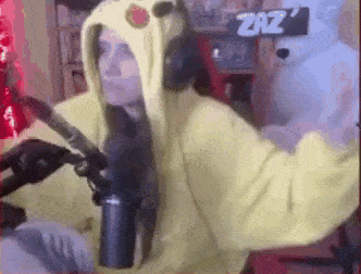 a woman wearing a pikachu costume is standing in front of a microphone .