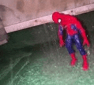 a toy spider man is standing in a pool of green water .