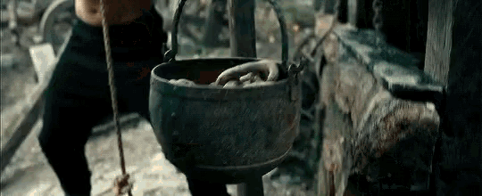a person is holding a rope around a pot with a hand in it .