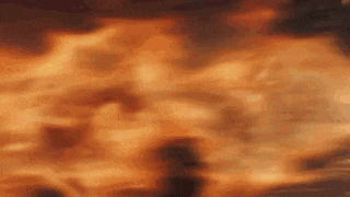 a close up of a fire with lots of flames coming out of it .