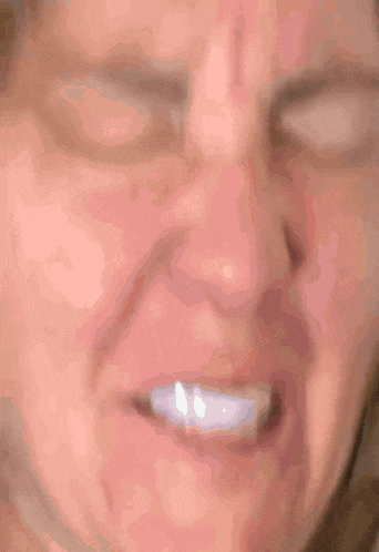 a close up of a woman 's face with her eyes closed and a smile on her face