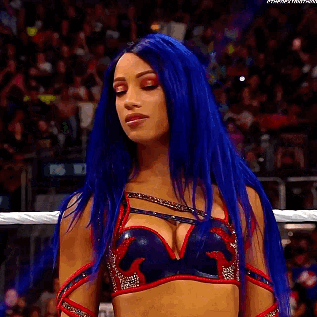 a woman with blue hair is standing in a boxing ring