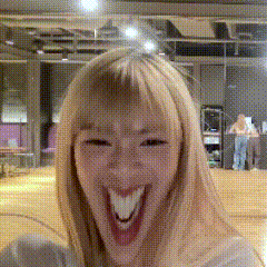 a woman with blonde hair is smiling with her mouth open
