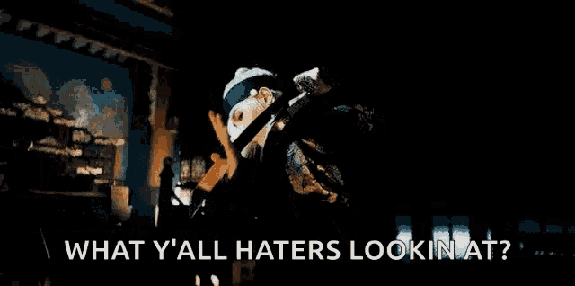 a woman is holding a microphone and a sword and says `` what y all haters lookin at '' .