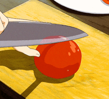 a person is cutting a tomato with a large knife