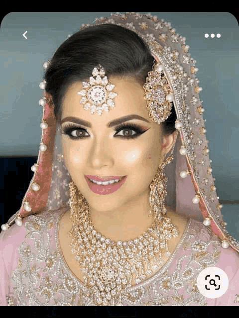 a bride wearing a pink and gold dress and jewelry