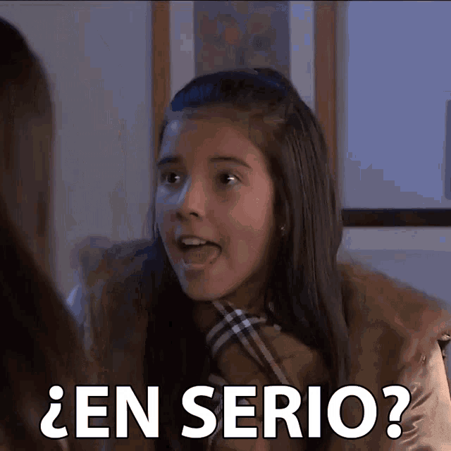 a girl is making a funny face and the words en serio are above her
