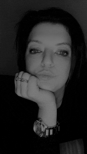 a woman wearing a watch and a ring is making a face