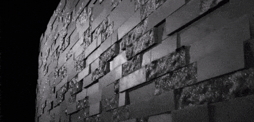 a black and white photo of a wall with a pattern of squares