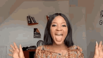 a woman is making a funny face with her tongue out and her hands up .
