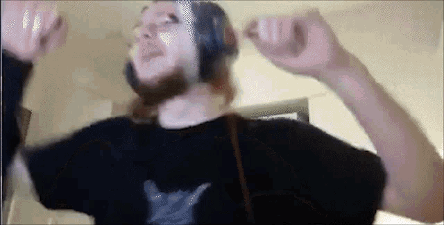 a man with a beard is wearing headphones and dancing .